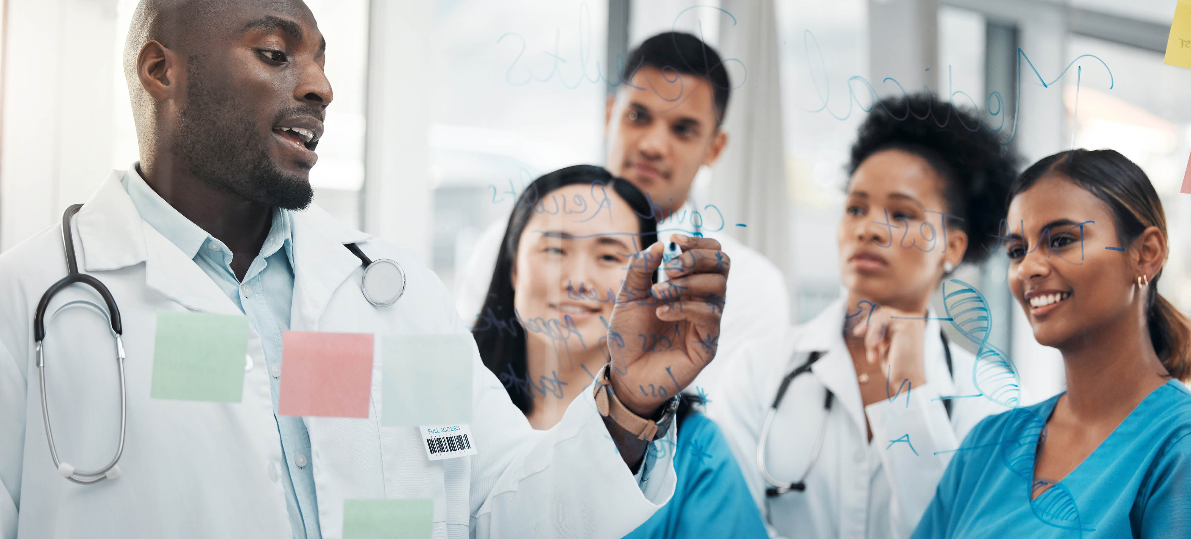 A doctor explains something on a transparent board to a group of diverse medical students, conveying teamwork and learning in a hospital setting.