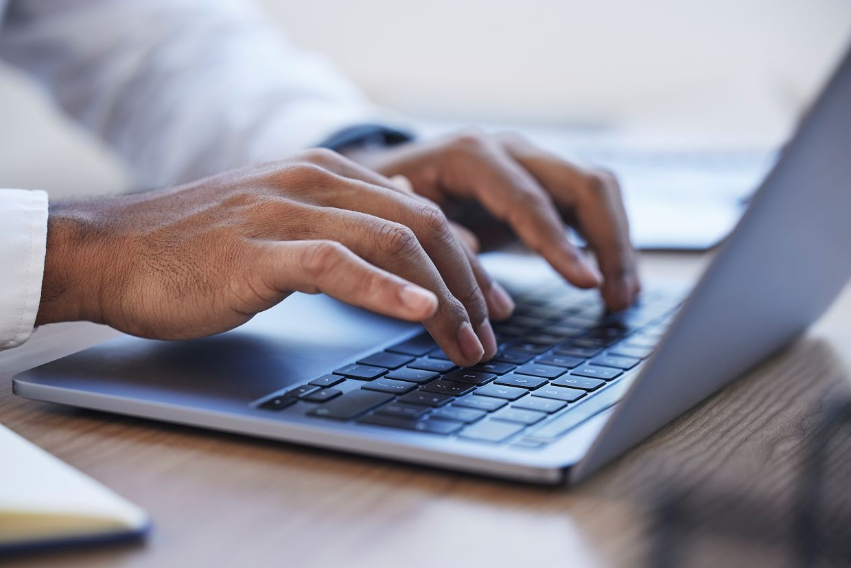 Male hands typing on a laptop